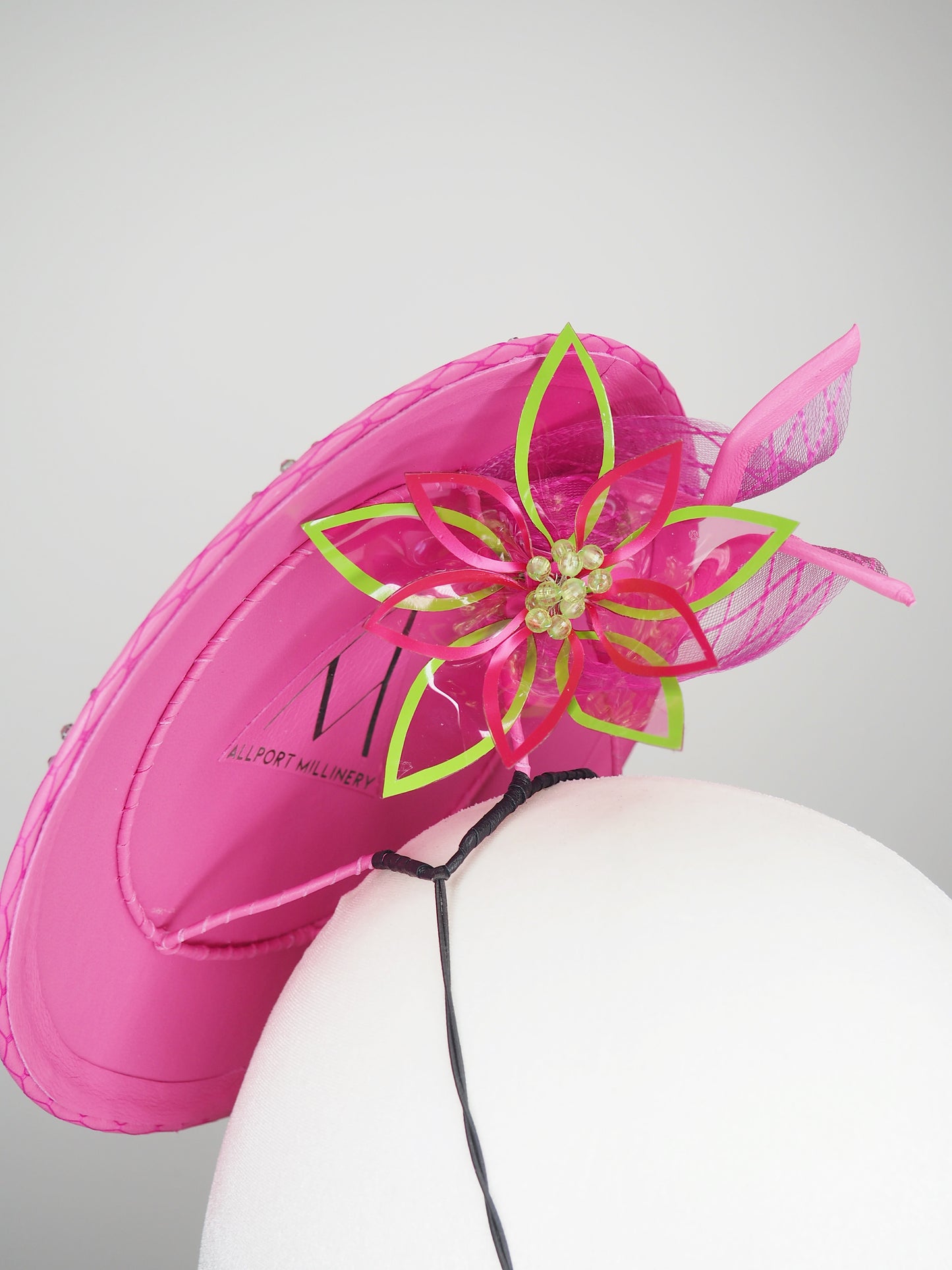 A Little Bit Wicked - Candy pink crystal encrusted leather disc with flower and wired swirl trim.