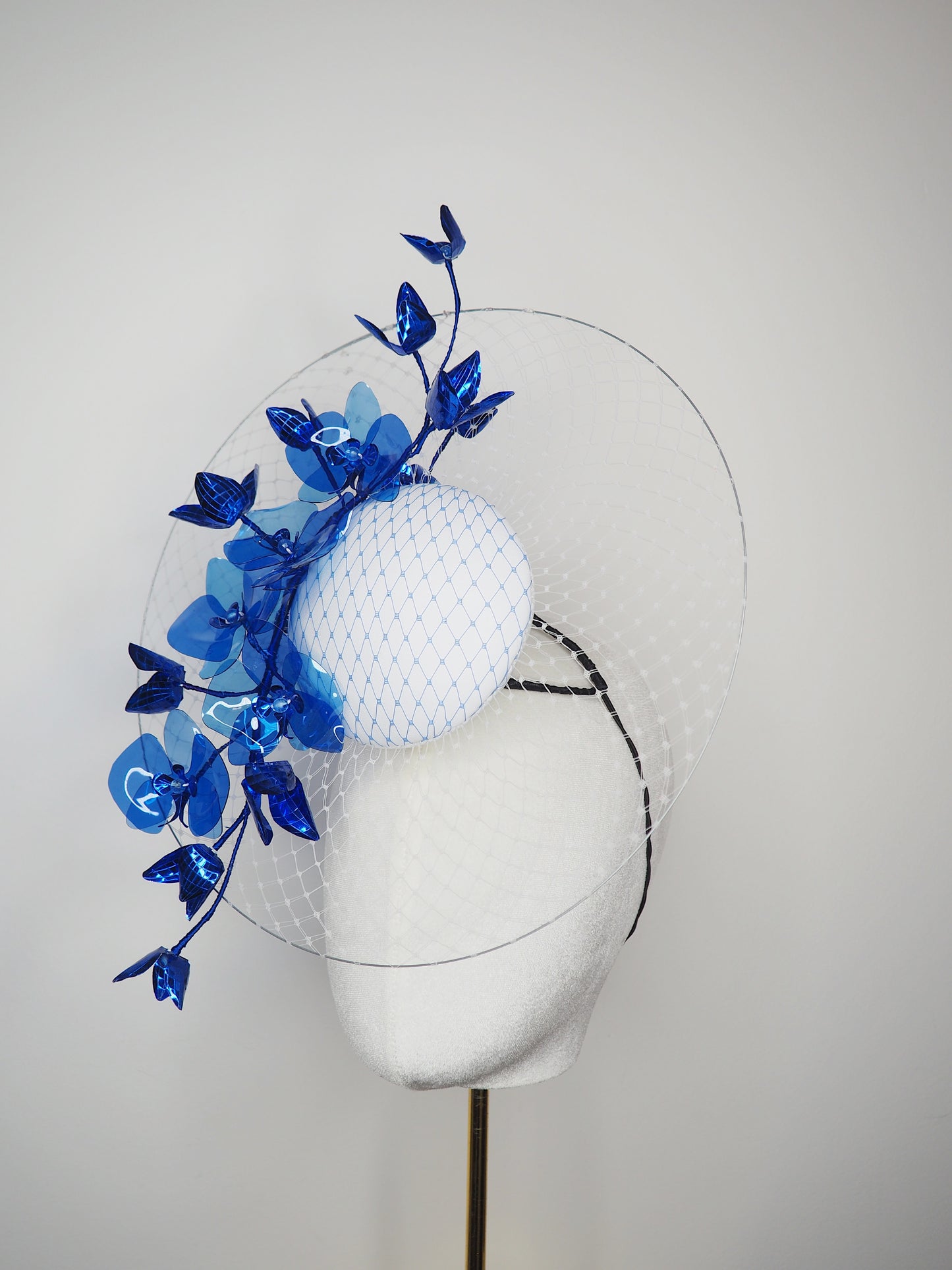 Dancing Orchids - Blue crystoform orchids on a white leather veiles percher base with veil detail