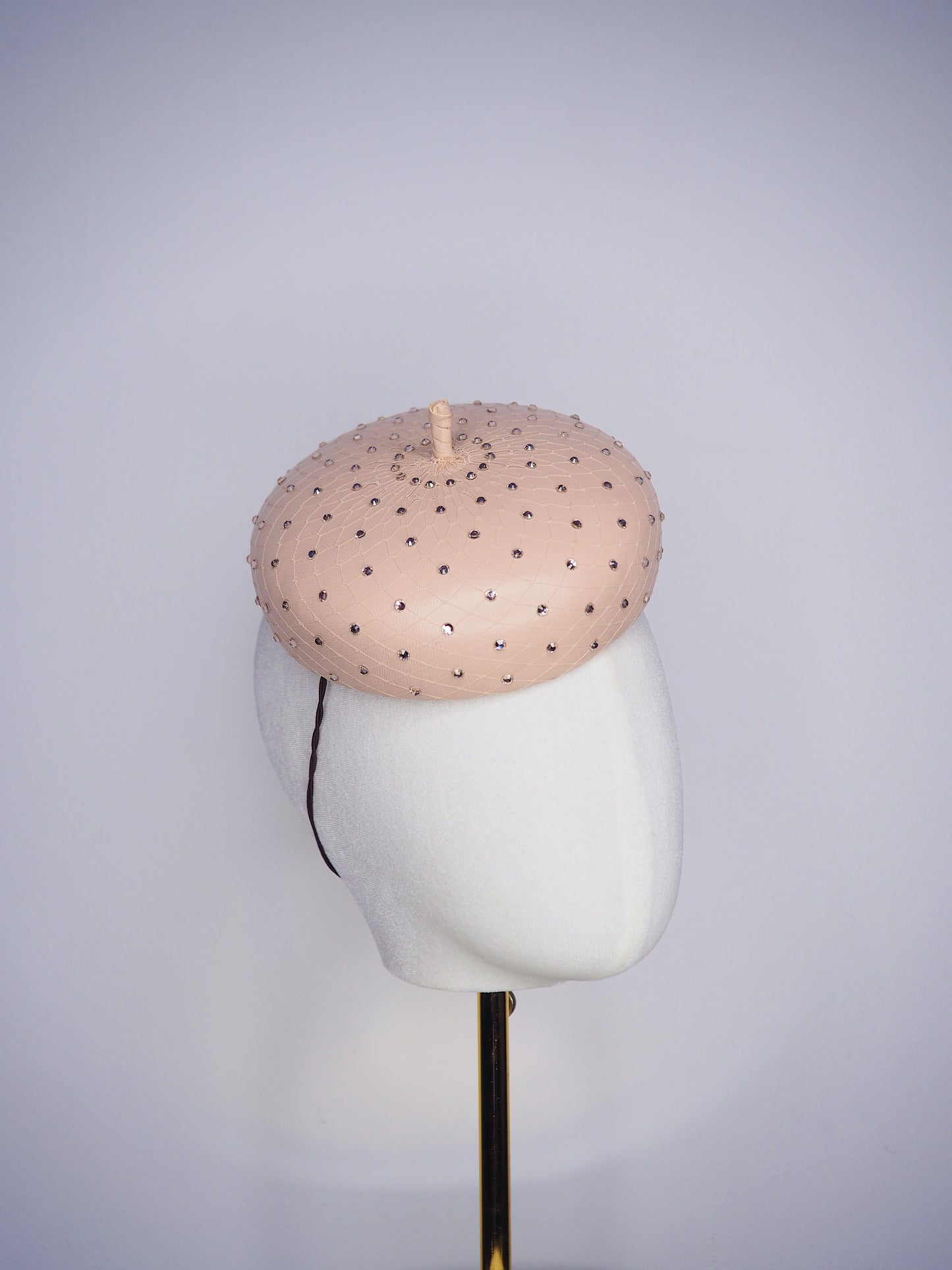 Morning Glow - A timeless nude button fascinator finished with blush crystals and elegant veiling.