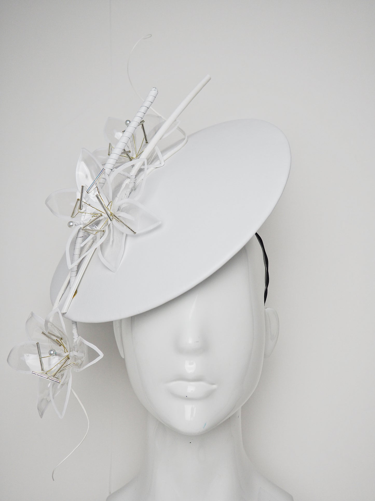 Lys En Blanc - White Crystoform Lillies on a floating leather disk with quill detail.