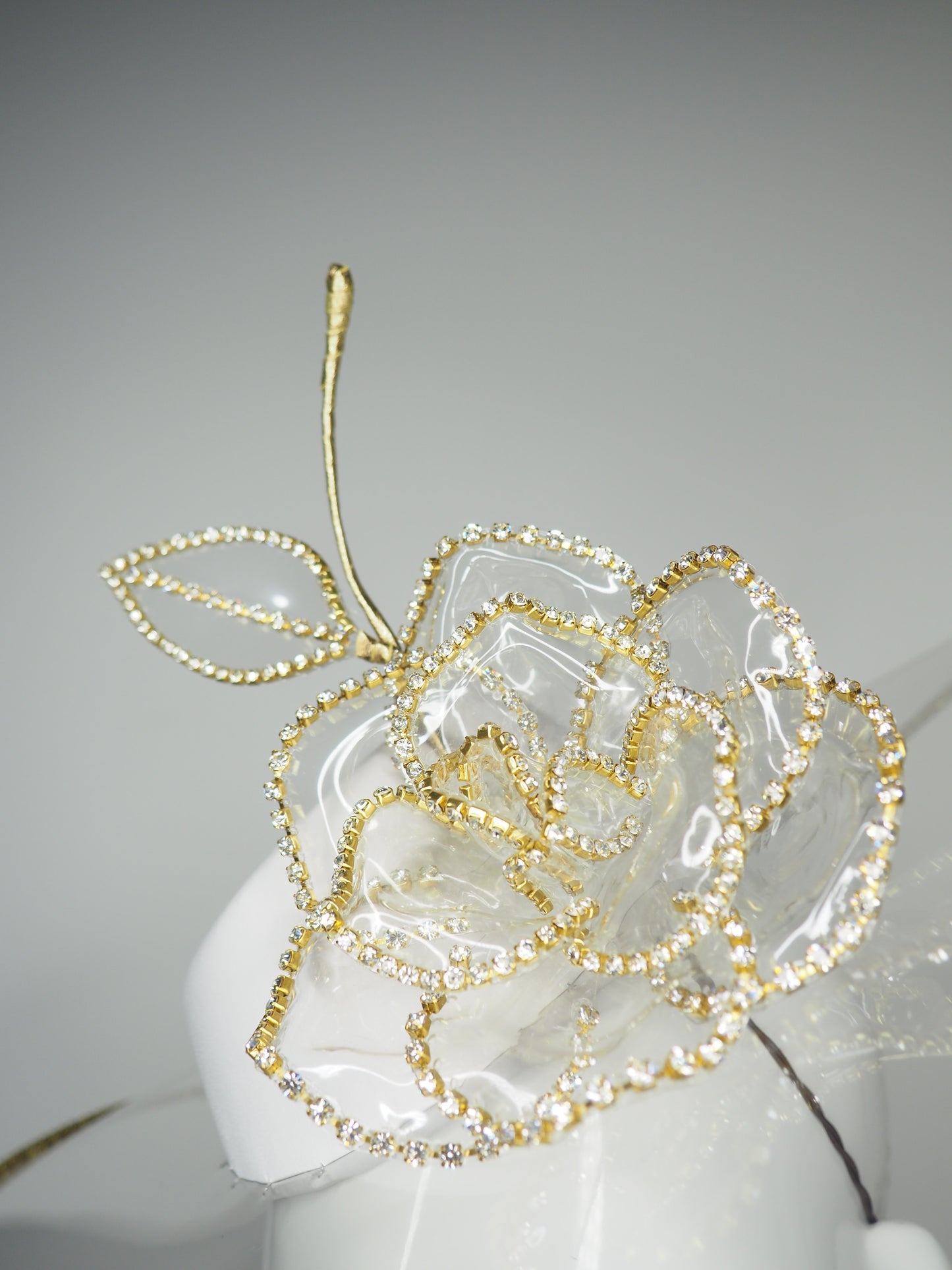 Golden Rose - Transparent peekaboo embellished brim withwhite leather crown and gold crystoform chain rose.