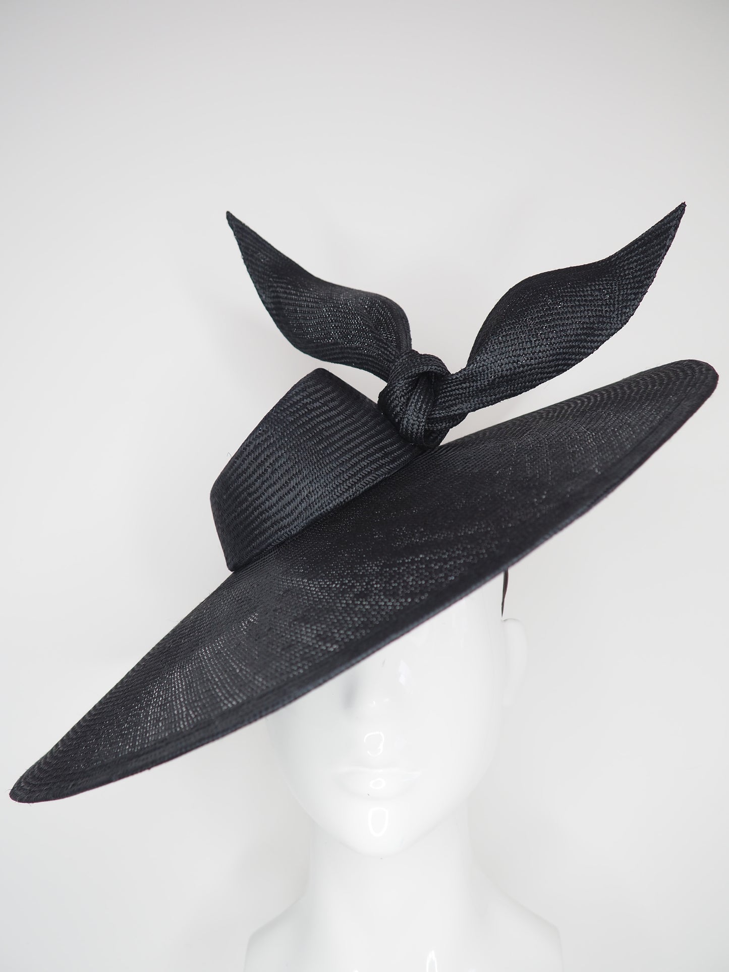Derby Pose- Slanted brim parisissal straw with asymmetric crown and wires knot detail