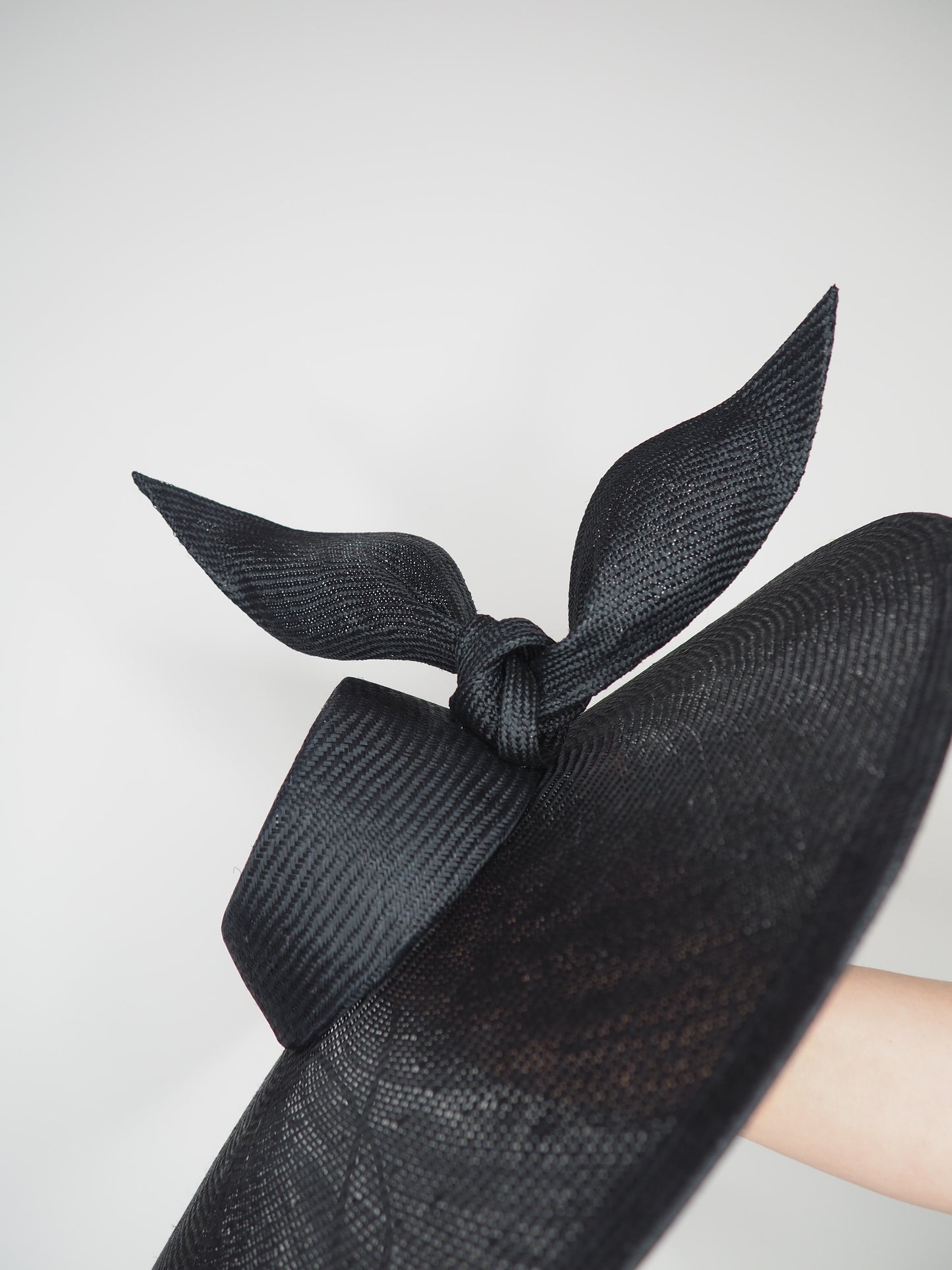 Derby Pose- Slanted brim parisissal straw with asymmetric crown and wires knot detail