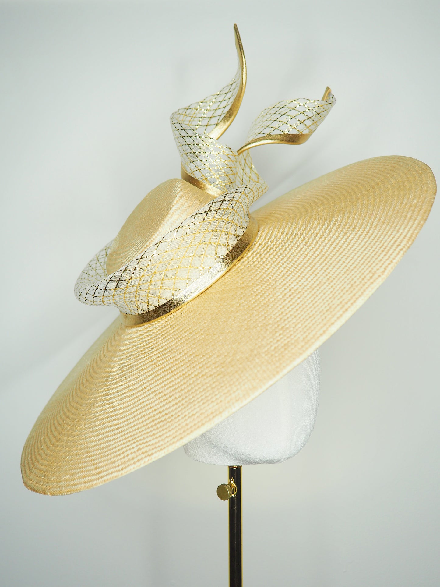 Gilded horizon  - Natural Straw broad brimmed slanted crown parissisal with white and gold lurex leather edged swirl crinoline detail.