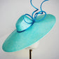 Sea Glass - A dramatic pale aqua asymmetrical brim featuring a sculptural turquoise bow, crystal detailing and delicate veiling.