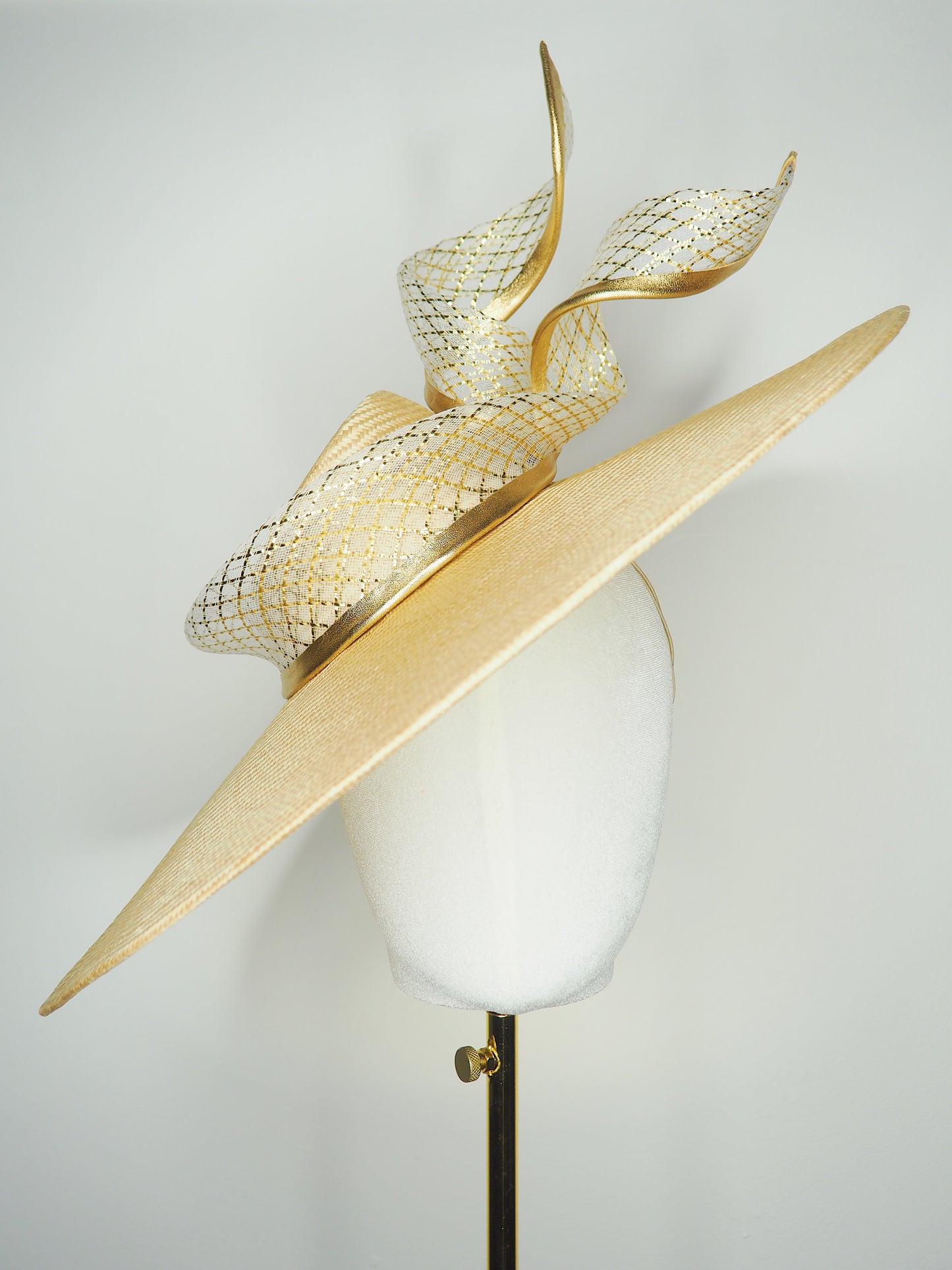Gilded horizon  - Natural Straw broad brimmed slanted crown parissisal with white and gold lurex leather edged swirl crinoline detail.