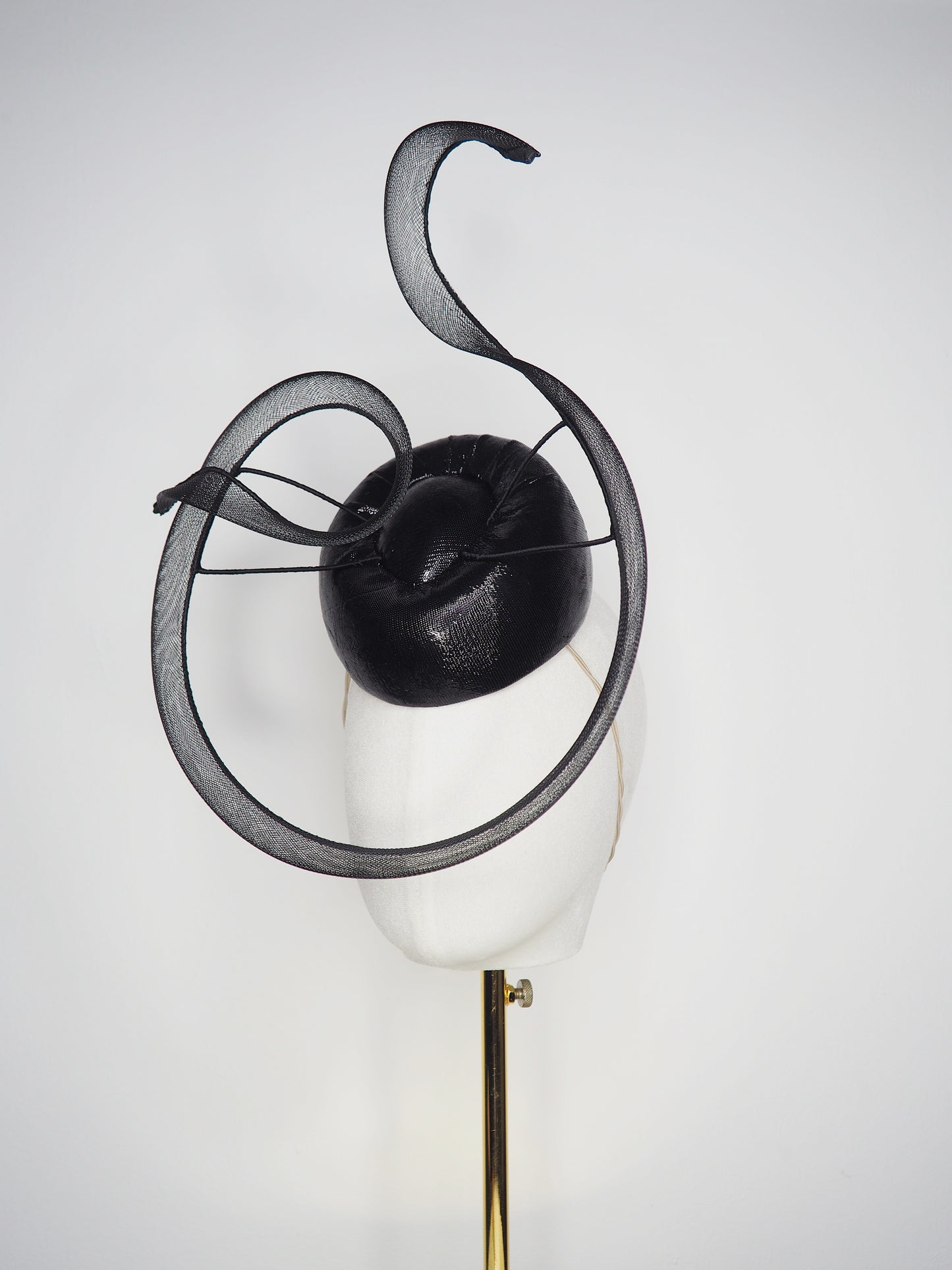 Black Swan - A sleek black lurex pillbox inspired by the graceful silhouette of a swan gliding across water.