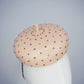 Morning Glow - A timeless nude button fascinator finished with blush crystals and elegant veiling.