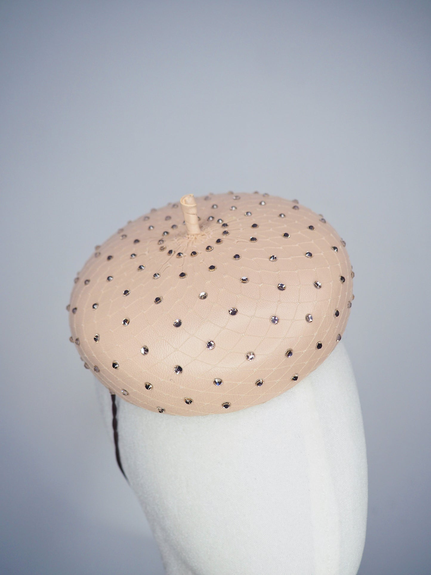 Morning Glow - A timeless nude button fascinator finished with blush crystals and elegant veiling.