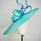 Sea Glass - A dramatic pale aqua asymmetrical brim featuring a sculptural turquoise bow, crystal detailing and delicate veiling.