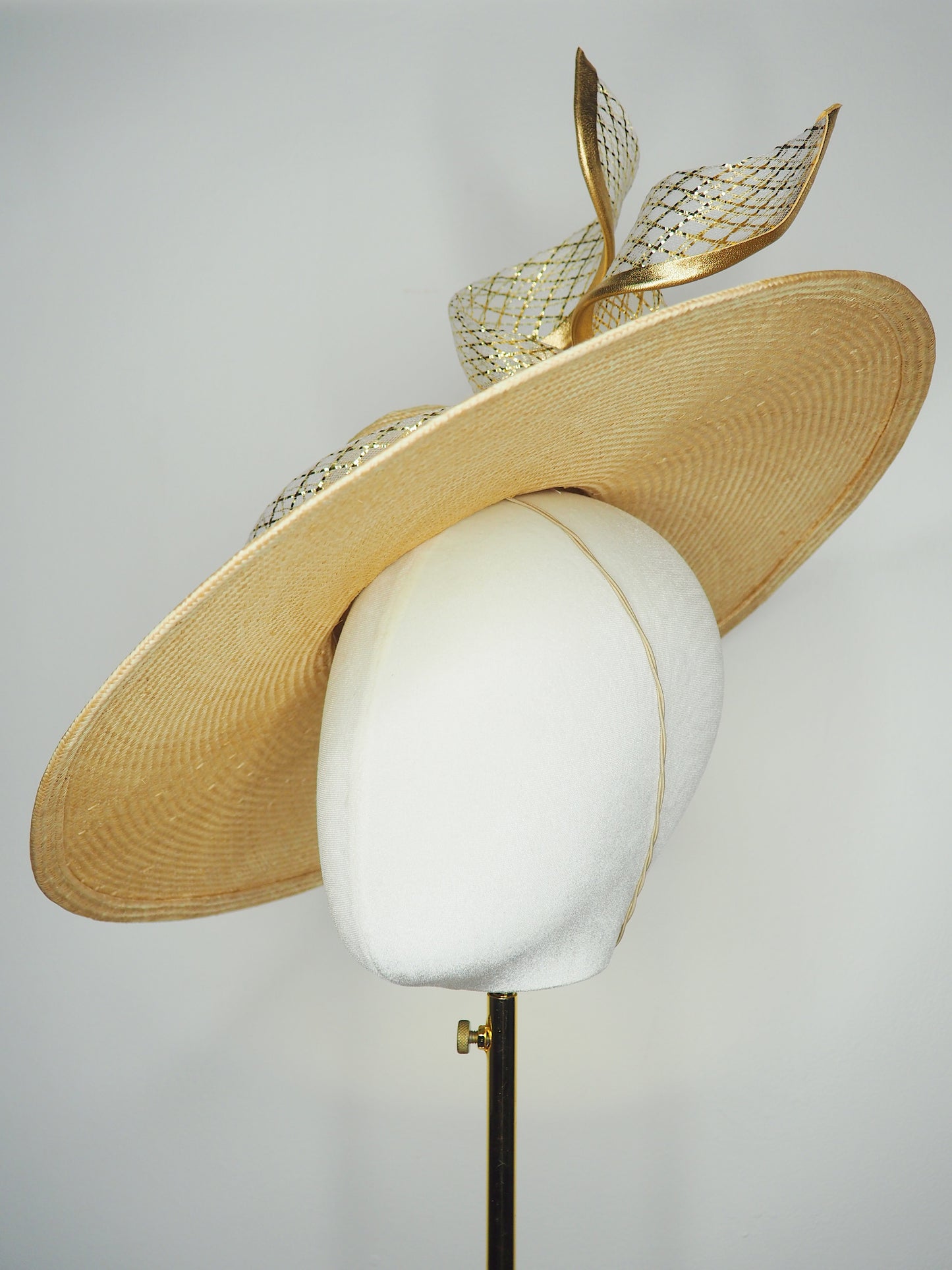 Gilded horizon  - Natural Straw broad brimmed slanted crown parissisal with white and gold lurex leather edged swirl crinoline detail.