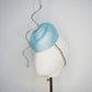 Blue Lagoon - A sophisticated pale aqua pillbox layered with shimmering lurex mesh and sculptural metallic swirls.