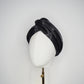 Glass Lake - A sculptural blocked turban crafted from luminous fabric inspired by morning reflections on water.