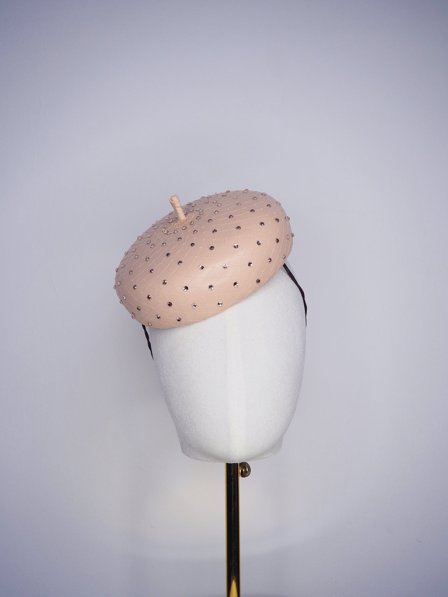 Morning Glow - A timeless nude button fascinator finished with blush crystals and elegant veiling.