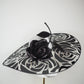 De Ville Rose - Sweeping crystoform wired brim with black rose petal pattern and single shiny dramatic rose with white leather veiled crown