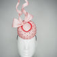 Cupids Bow - Baby pink Pork pie Pillbox with red veil and crystal detail and sculpted bow.