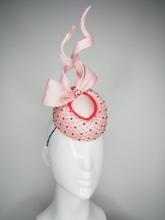 Cupids Bow - Baby pink Pork pie Pillbox with red veil and crystal detail and sculpted bow.