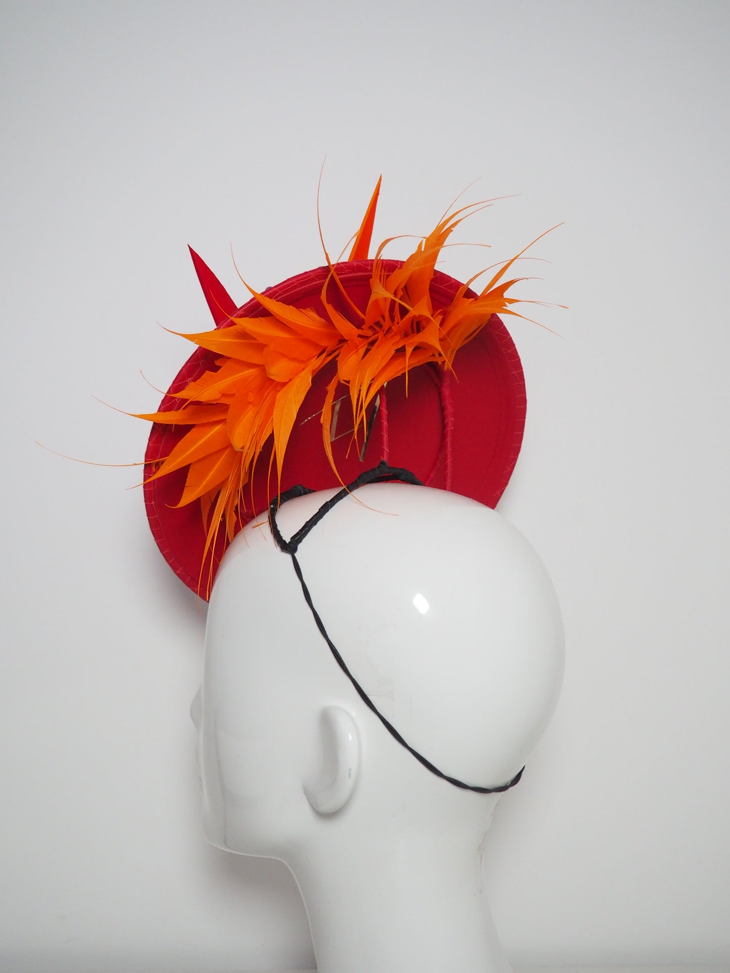 Out of the fire - Red leather percher disc with hyacinth orange diamantés trimmed quills and wired feather spray