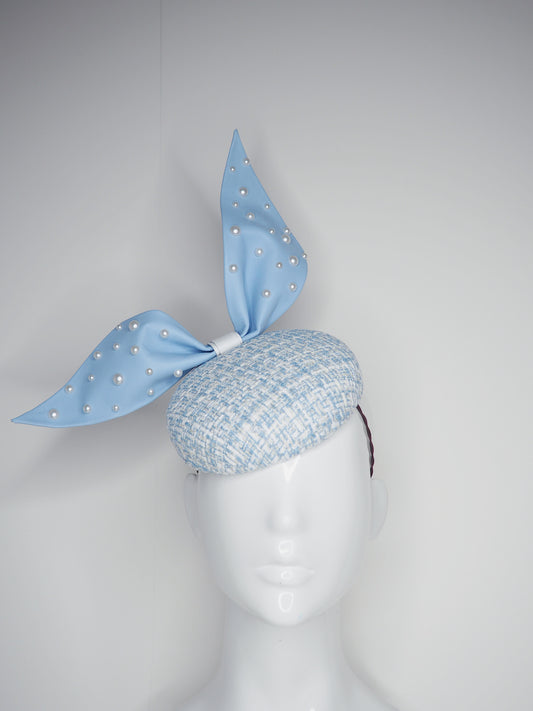 Blue pearl - Blue wired leather bow with pearl feature on a white and blue tweed button base with lurex flecks