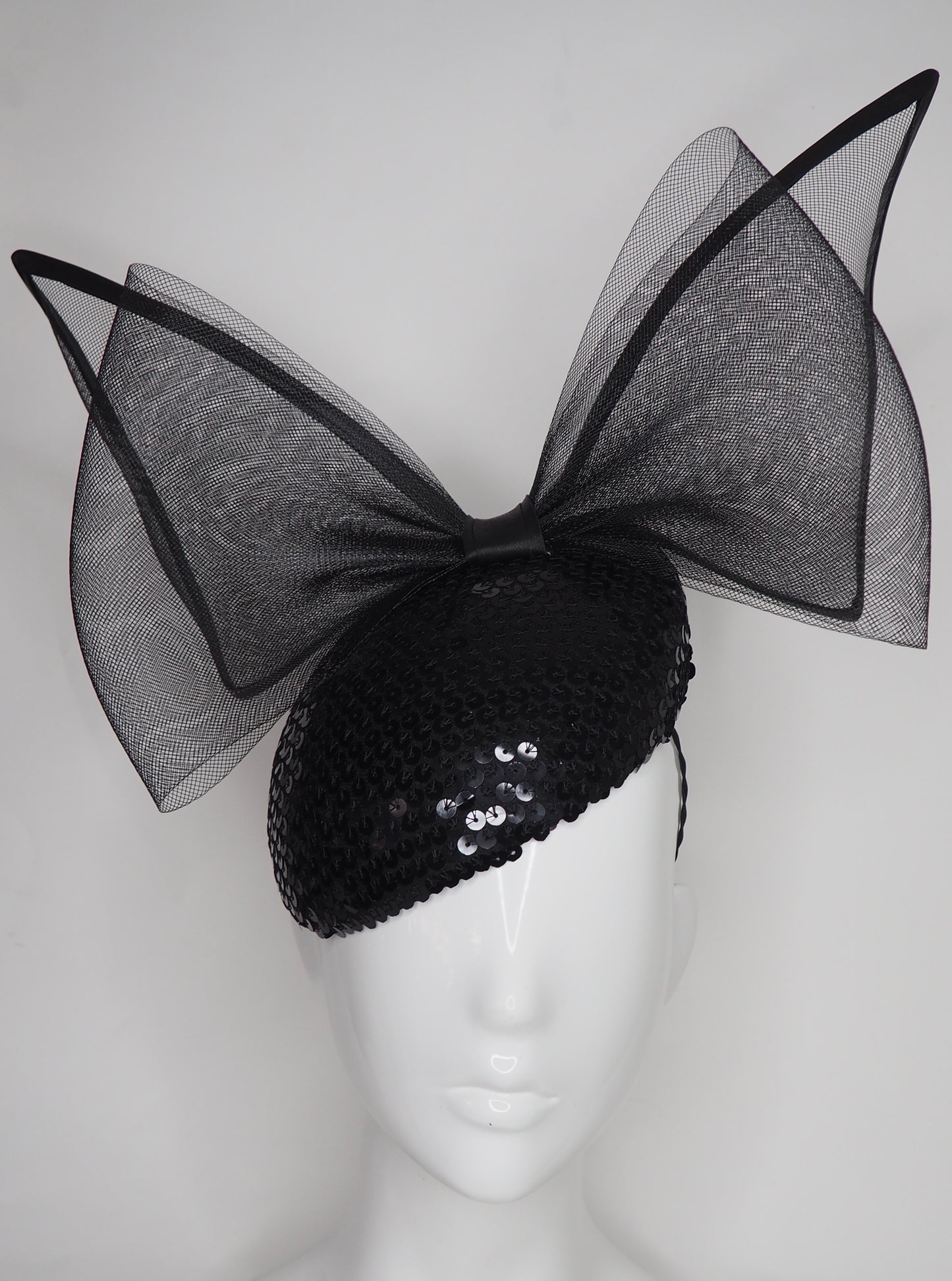 Sequin Sass - Black wired crinoline bow on a sequin facehugger base